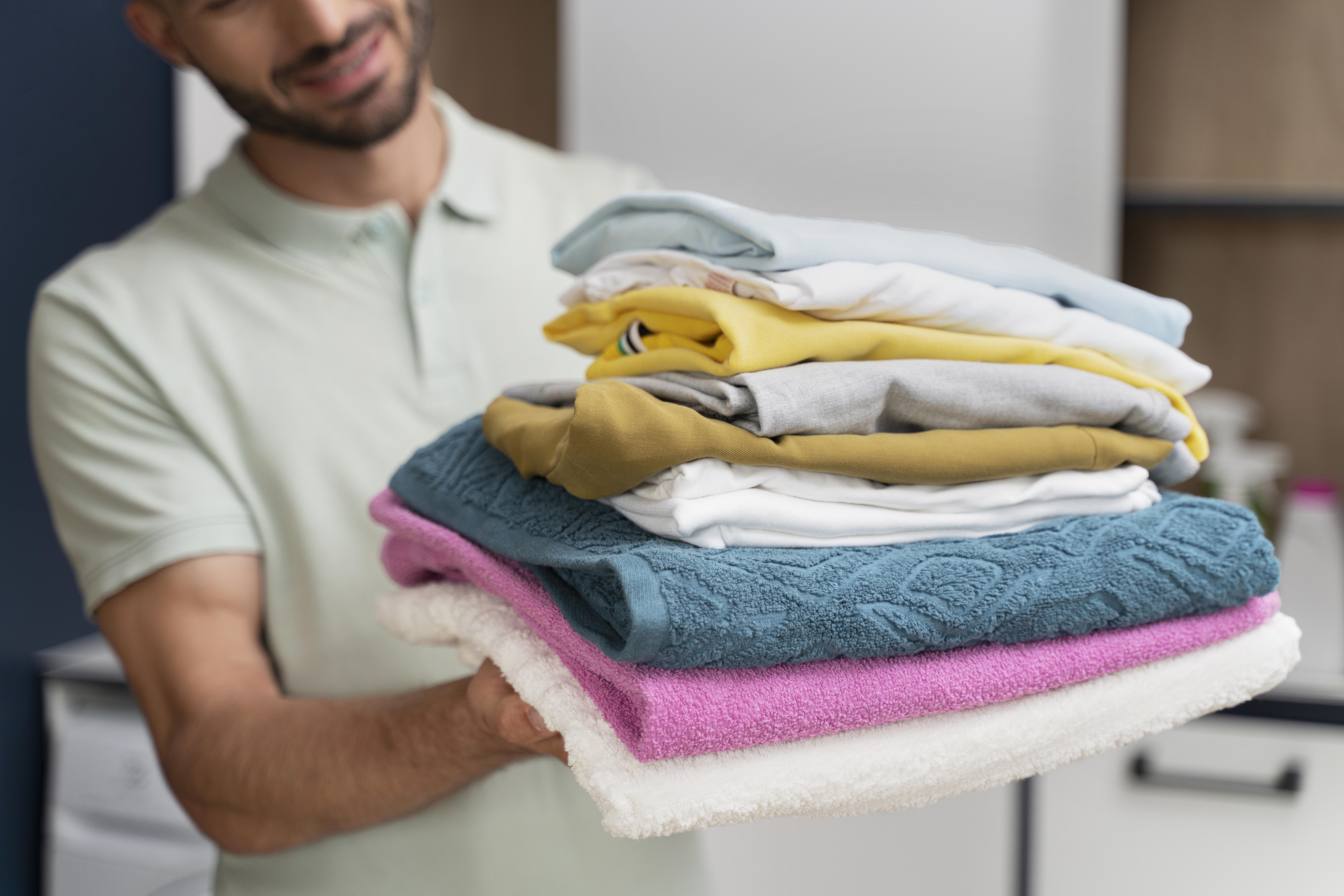 man-holding-pile-clothes