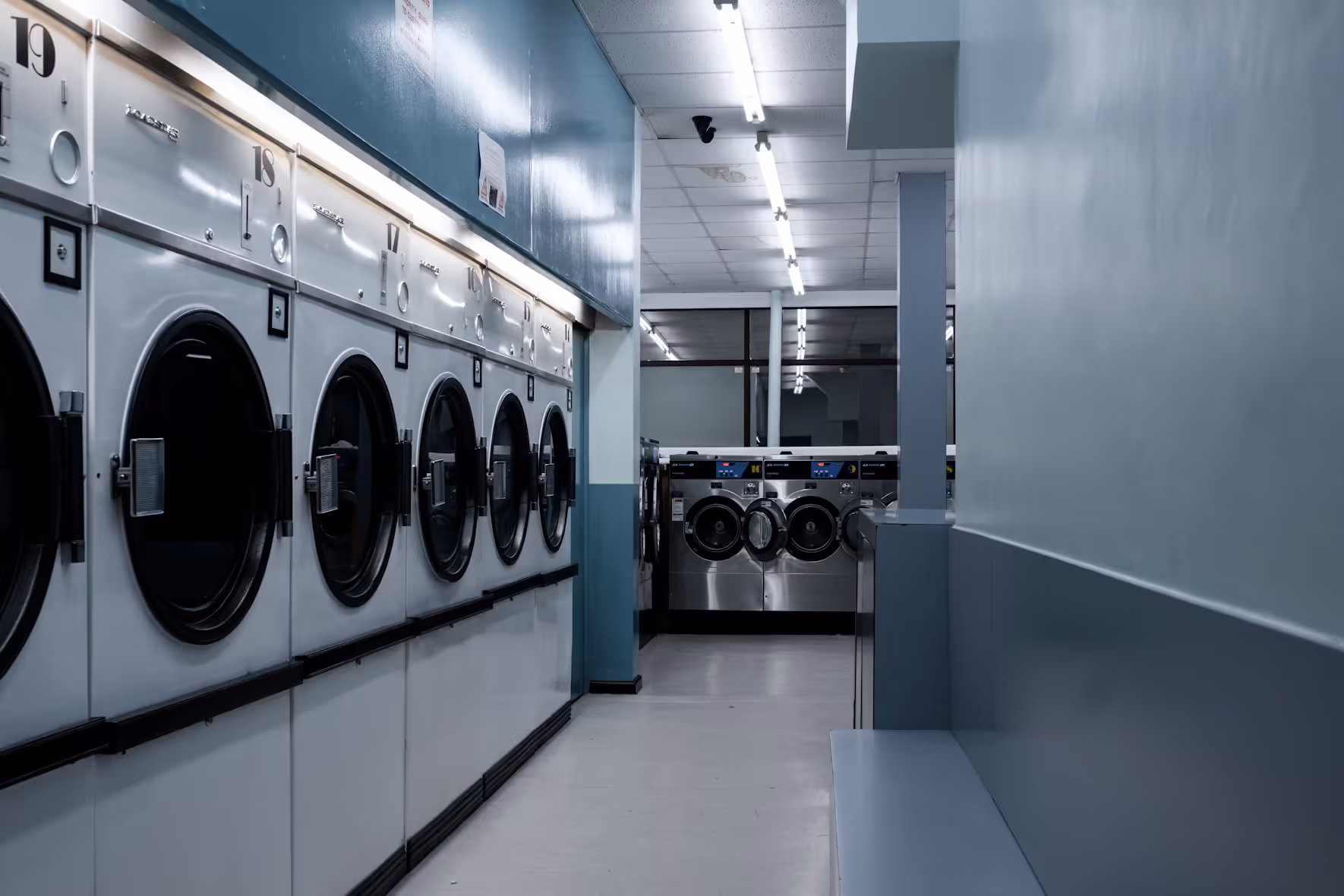 The image shows us series of washing machines like in a laundry servicing room. 